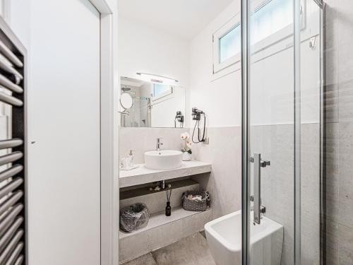 a white bathroom with a sink and a toilet at Corte Magnolia Terme & Lago di Garda in Colà di Lazise