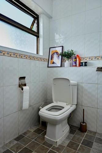 a bathroom with a white toilet and a window at Lakeview 3Bedroom Condo with heated pool in Nakuru Town in Nakuru