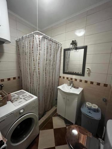 a bathroom with a washing machine and a sink at Be happy in Perast in Perast