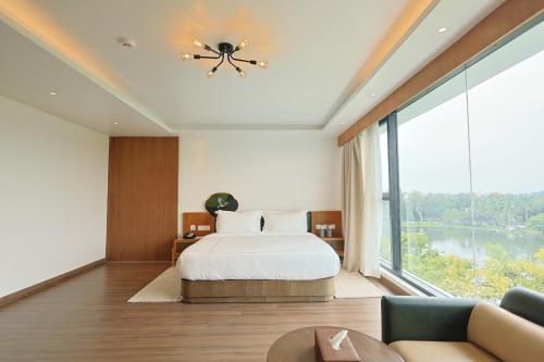 a bedroom with a bed and a large window at Royal Bishnu in Baharampur