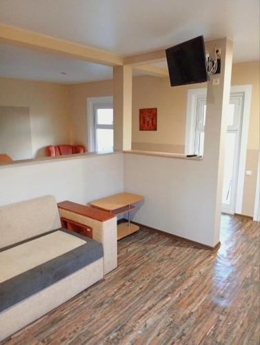 a room with a bed and a table and a tv at Villa Klavia in Zatoka
