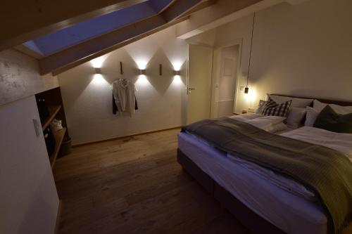 a bedroom with a large bed and lights on the wall at Das Alpiente - Das Urlaubshaus im Allgäu in Sonthofen