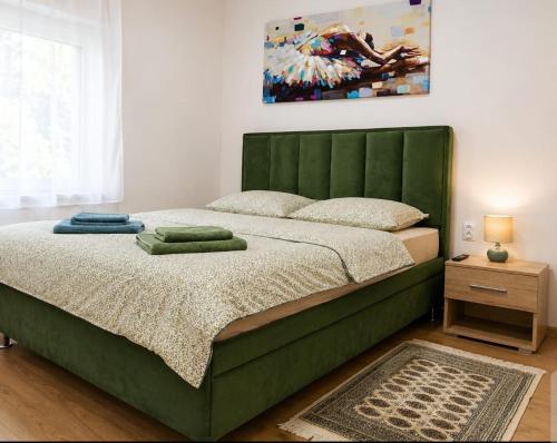 a green bed with a green headboard in a bedroom at Zaga Bloom Apartment in Banja Koviljača