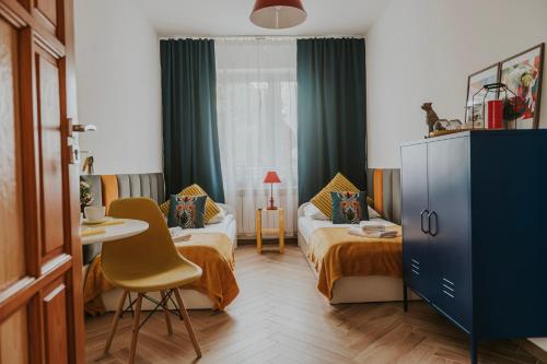 a hotel room with two beds and a table and chairs at Cztery Kąty Zator Energylandia Przeciszów in Przeciszów