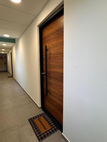 a wooden door in a hallway with a tile floor at 103 - Voiron centre - DeTassigny in Voiron