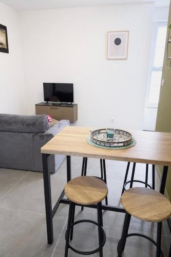 a table and two stools in a living room at 103 - Voiron centre - DeTassigny in Voiron