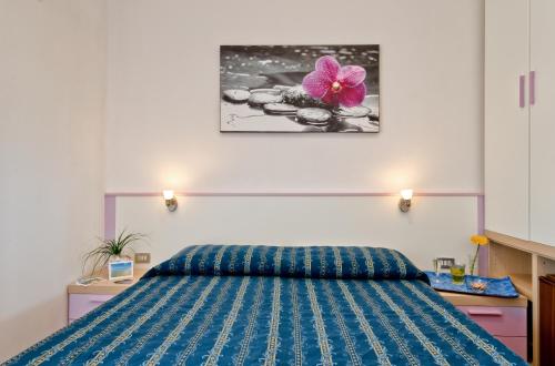 トッレ・ヴァードにあるAl Porticcioloのベッドルーム1室(壁に花を飾ったベッド1台付)