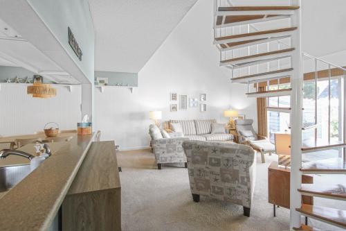 a kitchen and living room with a spiral staircase at Coastal Cozy in Brewster