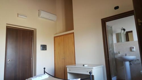 uma casa de banho com um WC, um lavatório e um espelho. em Oasi Di Francesca em Gerbini