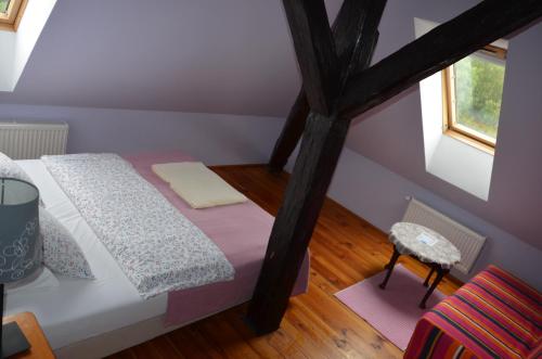 a small attic bedroom with a bed and a window at Stara Szkoła w Harszu in Pozezdrze