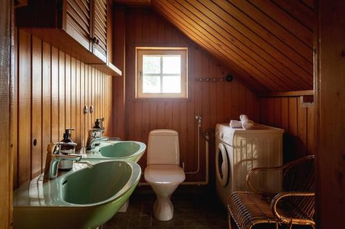 a bathroom with three sinks and a toilet at Stay North - Mustio in Inkoo
