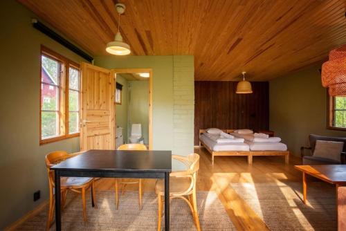 a living room with a table and chairs and a bed at Stay North - Mustio in Inkoo