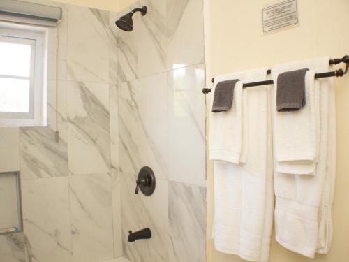 a bathroom with a shower with white towels at The Vista Inn Studio #4 in Falmouth