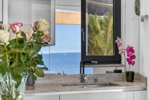 a kitchen sink with a vase of flowers and a window at Villa Paradise in Éze