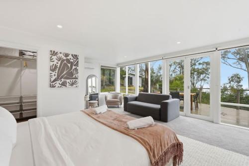 a bedroom with a large bed and a living room at Bush Escape with Water Views in Tinderbox