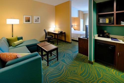 a hotel room with a couch and a bed at SpringHill Suites Terre Haute in Terre Haute