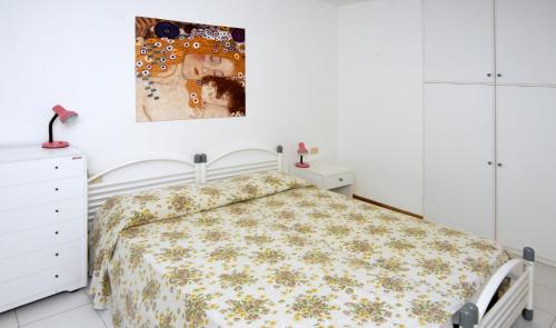 ビビオーネにあるLe Caravelleのベッドルーム1室(ベッド1台付)が備わります。壁には絵画が飾られています。