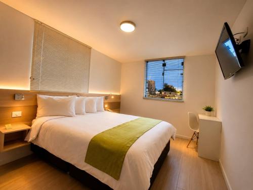 a bedroom with a large bed and a television at Natura Inn Hotel in Arequipa