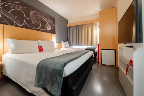 a bedroom with a large bed in a hotel room at Ibis Porto Alegre Assis Brasil - Estacionamento Gratuito para hospedes in Porto Alegre