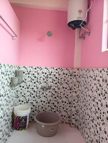 a bathroom with a pink wall and a sink at itynnad homestay in Shillong