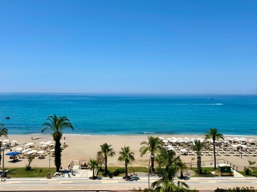 a view of a beach with palm trees and the ocean at SA Apartments! Beachfront Apartments in Oba in Alanya