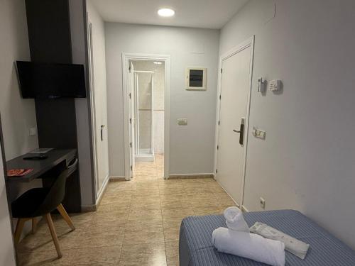 a room with a bed and a desk and a hallway at Hotel Barajas Plaza in Madrid