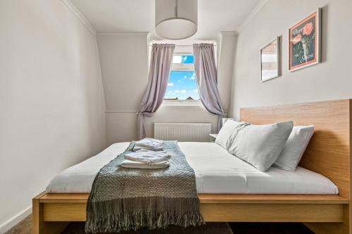 a small bedroom with a bed with a window at Smart TV, Nespresso machine, Self Check-In in Potter Street
