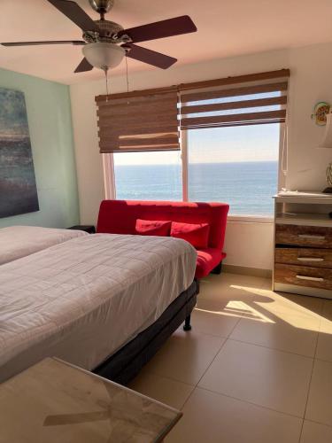 a bedroom with a bed and a window with the ocean at Casa Aqua in Monterrico