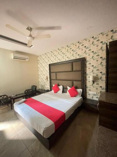 a bedroom with a large bed with red pillows at Hotel Surya Palace - Durg Railway Station in Durg