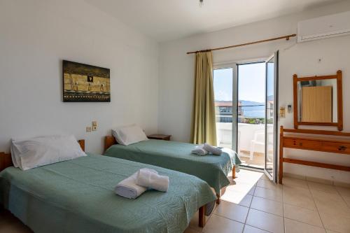 two beds in a room with a balcony at Nautilus Apartments in Sisi