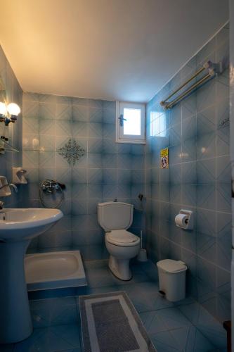 a blue tiled bathroom with a toilet and a sink at Nautilus Apartments in Sisi