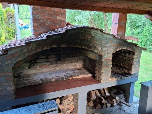 an outdoor brick oven with a wooden roof at Plaža STEFIN KUTAK in Rudice