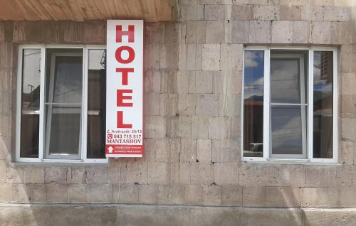 a sign on the side of a building with two windows at Hotel MANTASHOV in Meghri