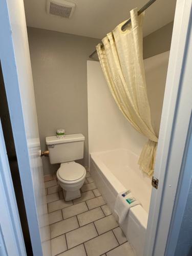 a bathroom with a toilet and a tub and a sink at Extend-a-Suites Phoenix in Phoenix