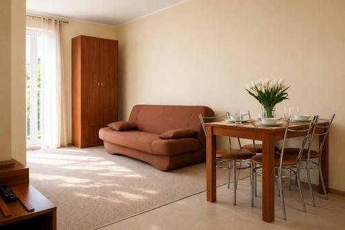 a living room with a table and a couch at Pensjonat Marynarski - Apartamenty in Darlowko