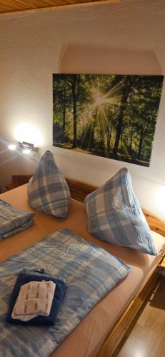 two beds with pillows and a picture on the wall at Jasmin mit Sauna und Schwimmbad in Hohegeiß