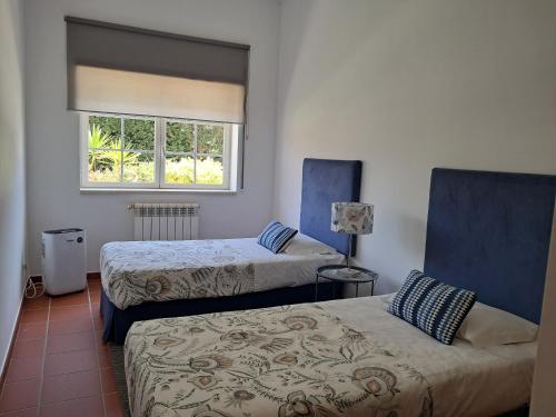 a room with two beds and a window at Praia Del Rei Pool in Amoreira