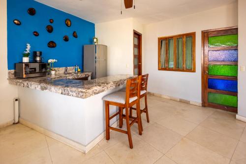 a kitchen with a counter and a chair at a bar at Blue Chairs Beachfront Resort Puerto Vallarta - Adults Only in Puerto Vallarta