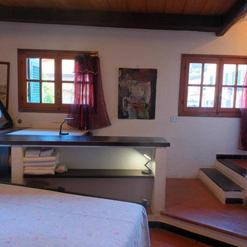 a bedroom with a bed and a desk with windows at Fontantica di Vernazza in Vernazza
