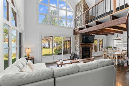 a living room with a white couch and a fireplace at Waterfront with VIEW and SPA in Saint-Raymond