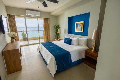 a bedroom with a large bed with a view of the ocean at Blue Chairs Beachfront Resort Puerto Vallarta - Adults Only in Puerto Vallarta