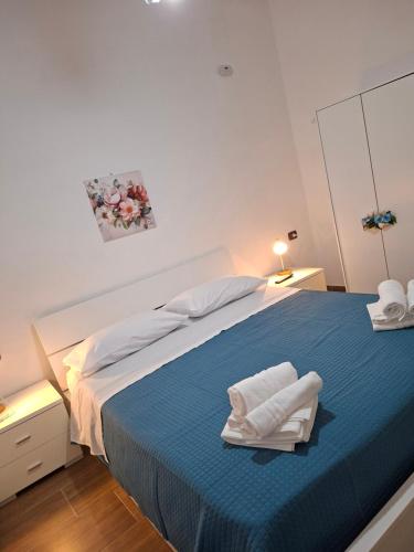 a white bedroom with a blue bed with towels on it at Don Pedro Home in Naples