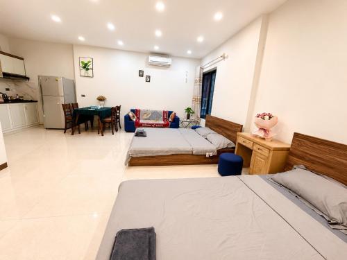 a bedroom with two beds and a dining room at MINGO House BA ĐÌNH in Hanoi