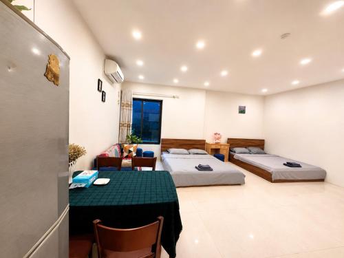 a room with two beds and a table and chairs at MINGO House BA ĐÌNH in Hanoi