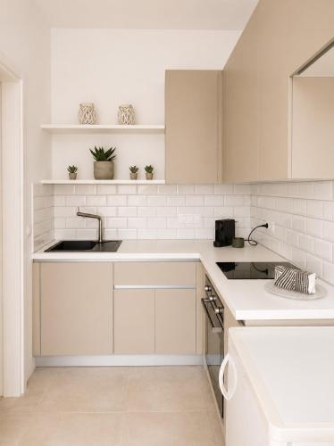 a kitchen with white cabinets and a sink at Aphrodite's Villa in Ambelas