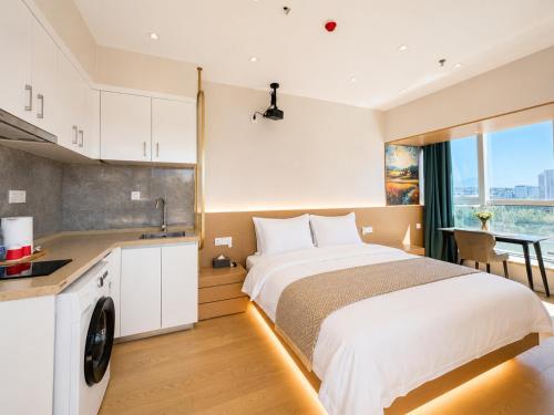 a bedroom with a large bed and a kitchen at Ancient City Garden Luxury Residence Xian in Xi'an