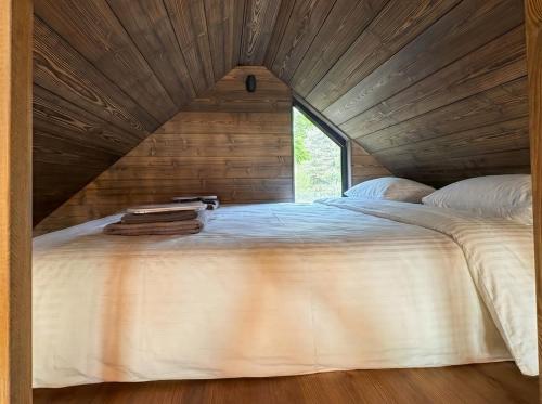 a large bed in a room with a wooden ceiling at Beržų oazės spa in Molėtai