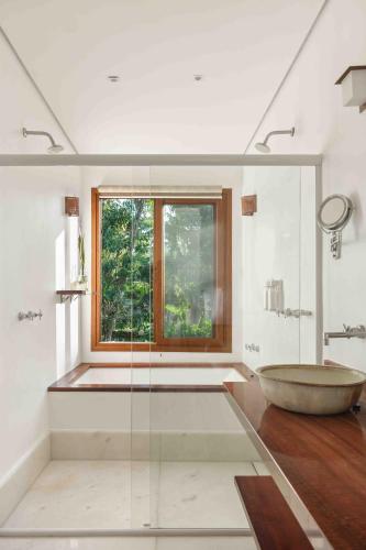 a bathroom with a large tub and a window at Odoyá Casa Hotel in Paraty