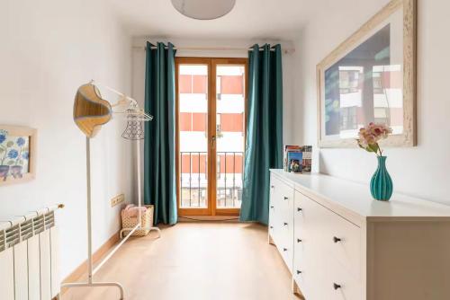 a room with a dresser and a window with green curtains at Apartamento junto al Ayuntamiento - by wehomes in Santander