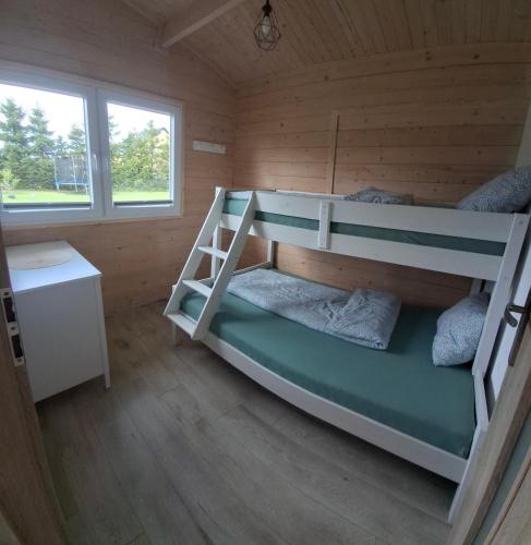 a bedroom with two bunk beds in a cabin at Urlopownia-Domki z Indywidulanym Ogrodzeniem-Dogfriendly-Duży,Zielony Teren in Gąski